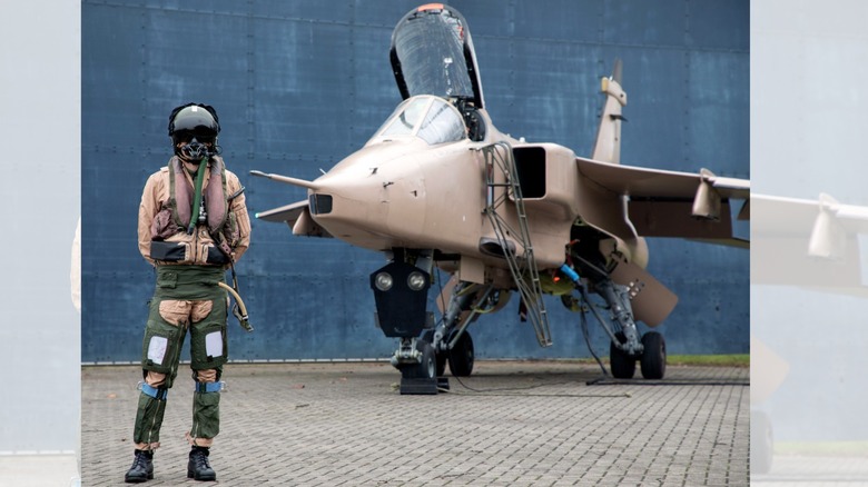 a fighter pilot in front of a fighter jet