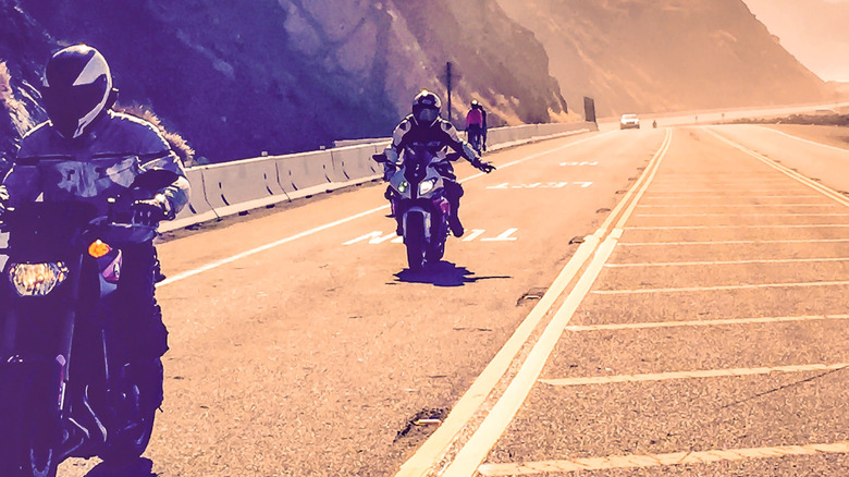 Two motorcyclists riding on road