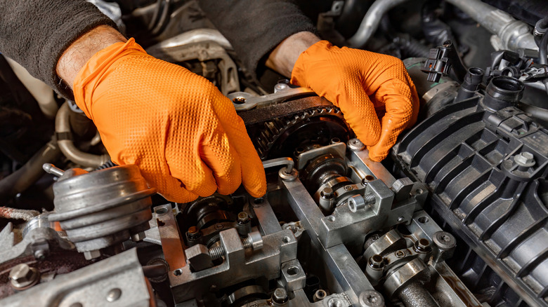 mechanic hands working on inside of car engine