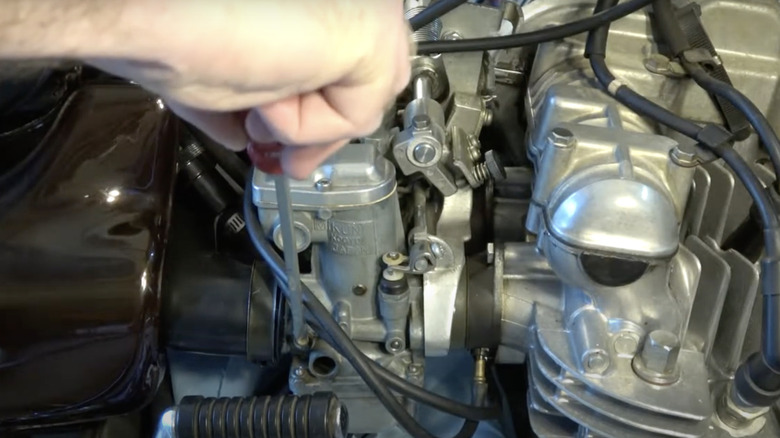 man adjusting idle screw on Kawasaki Z1a carburetor