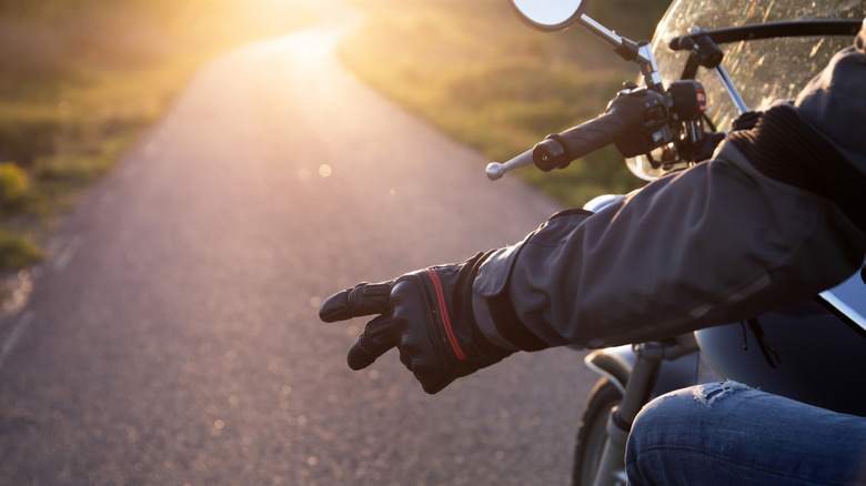 Biker with two horizontally outstretched figures on left hand