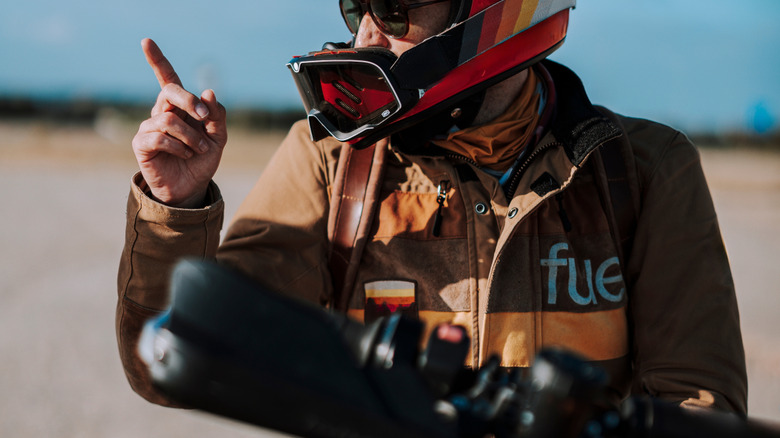 Man with helmet pointing upward