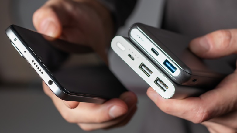 man holding phone and power banks