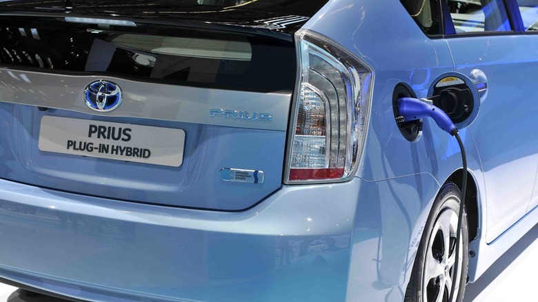 Rear 3/4 shot of a Toyota Prius PHEV plugged to a charger