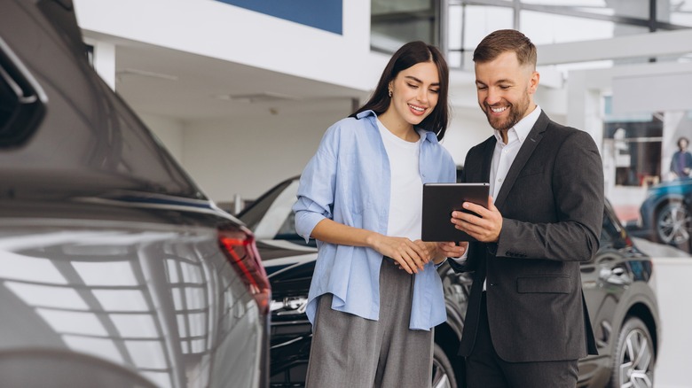 A female customer and a dealership agent discussing the car deals available