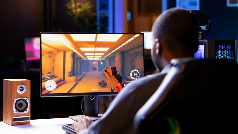 A man playing FPS game on his desktop PC