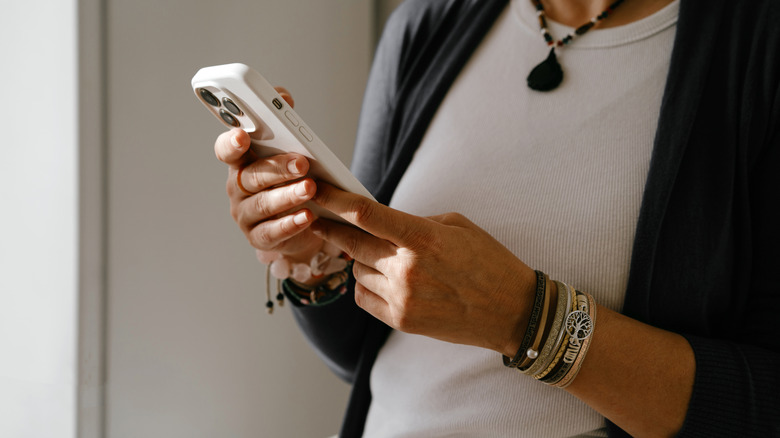 woman tapping on iphone screen