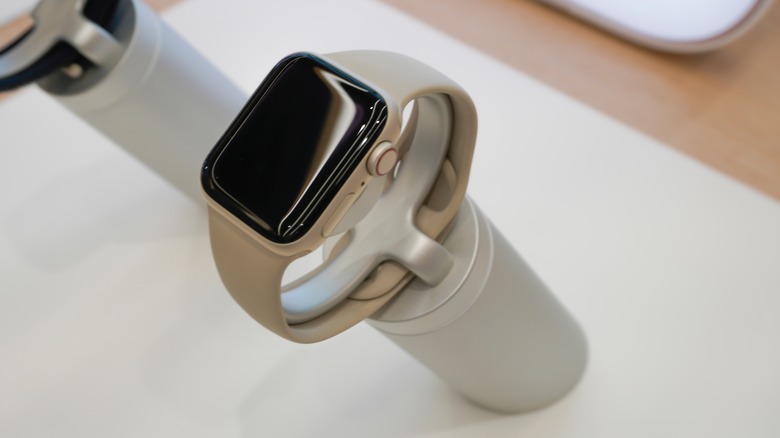 An Apple Watch SE with a rubber gold band on a display.