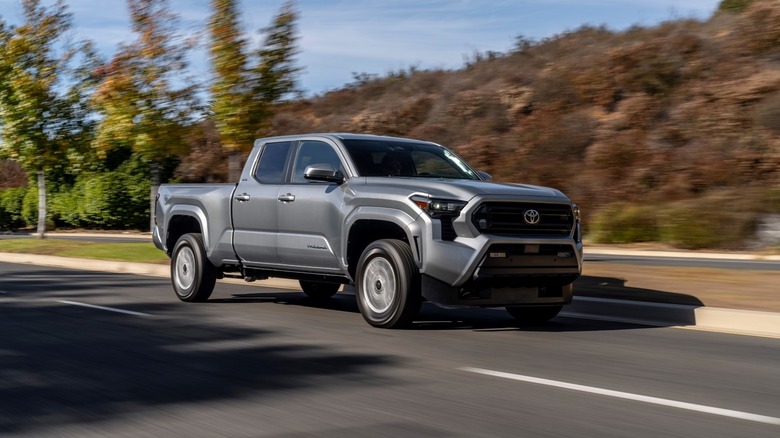 2024 Toyota Tacoma SR5 driving on a road with trees in the background