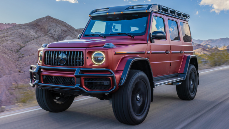 Red custom Mercedes G-Wagen driving on road