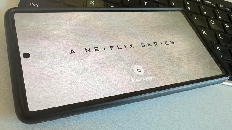 A lock icon appears on a Netflix show playing on a mobile phone