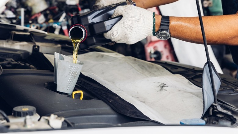 A person filling their engine with fresh, clean oil