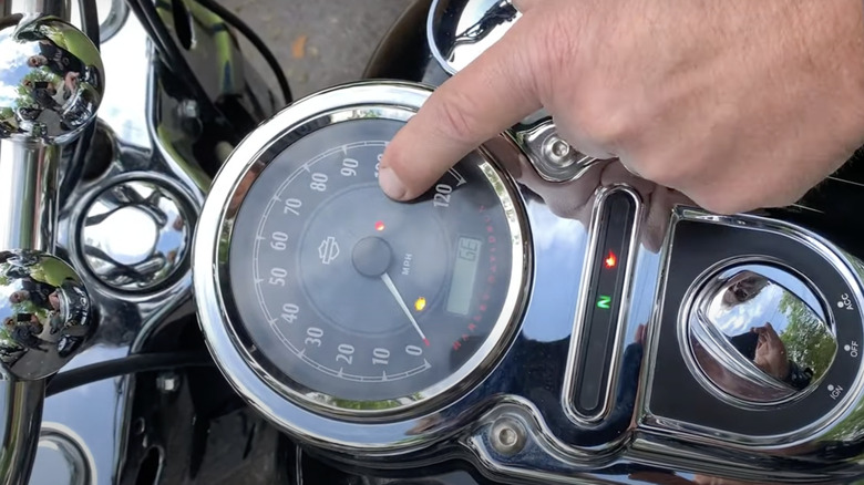 Finger pointing at Harley-Davidson warning light