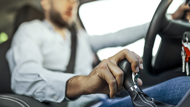 Person clutching gear shift