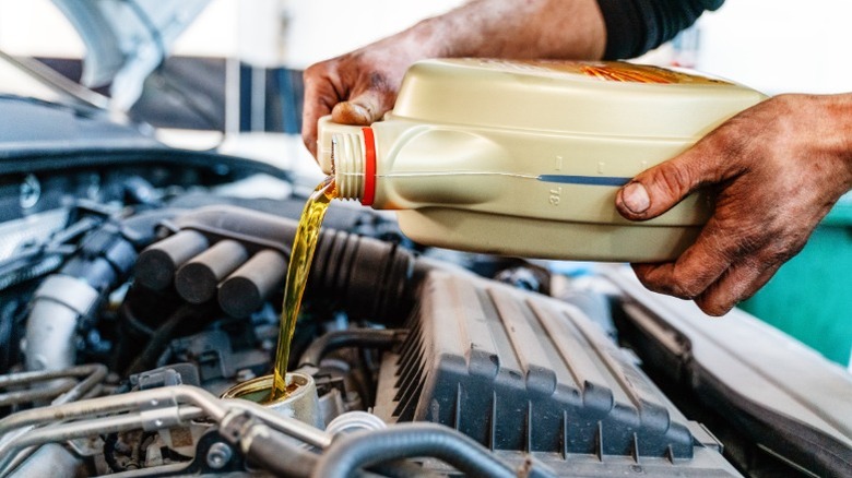 pouring oil into the car engine