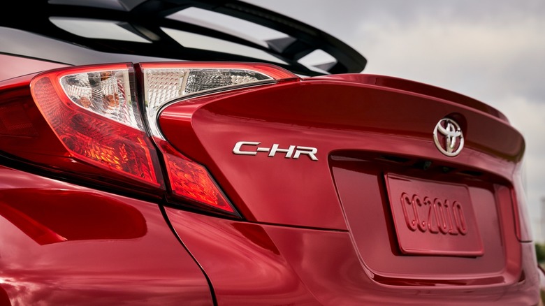 Rear three-quarter shot of a red Toyota CH-R showing the CH-R designation up close