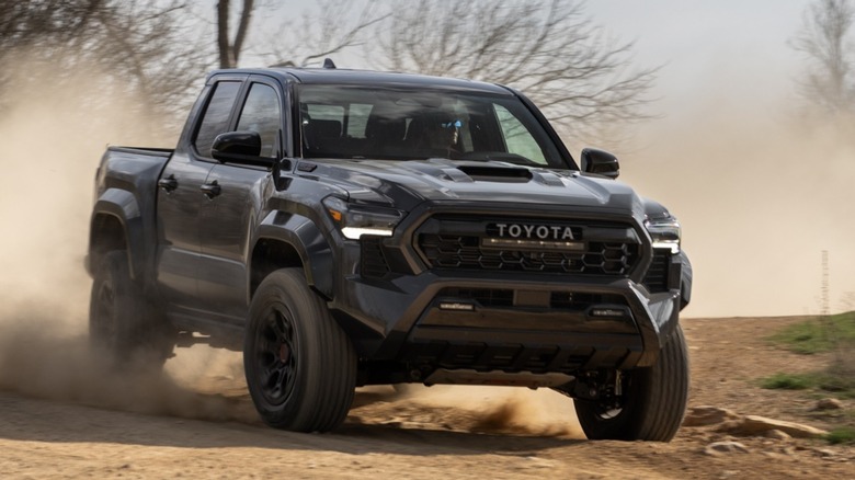 A Toyota Tacoma TRD Pro driving on a dusty road.