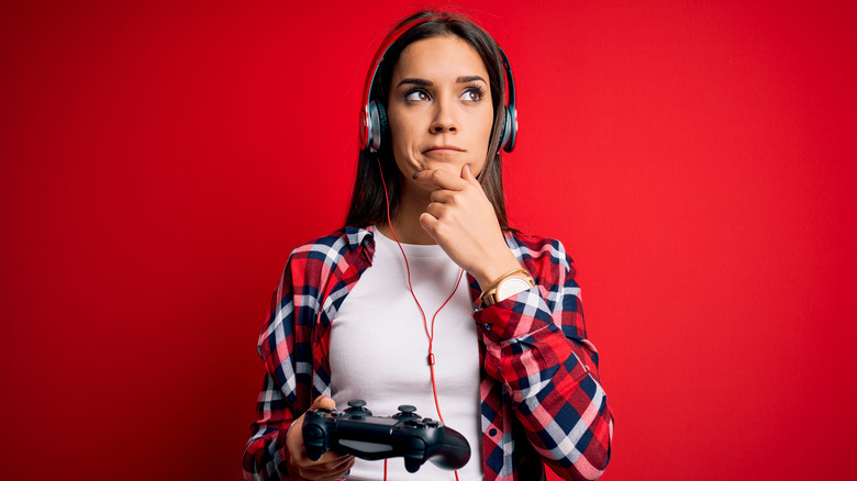 Confused woman holding gaming controller