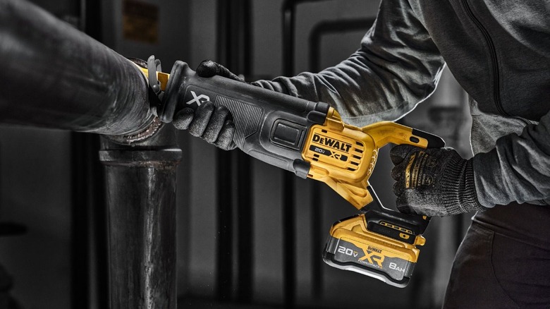 Person using saw to cut a pipe