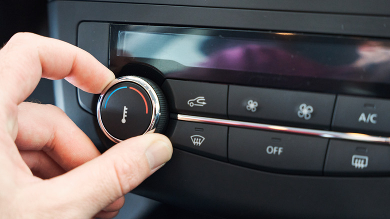 hand twisting car temperature control dial