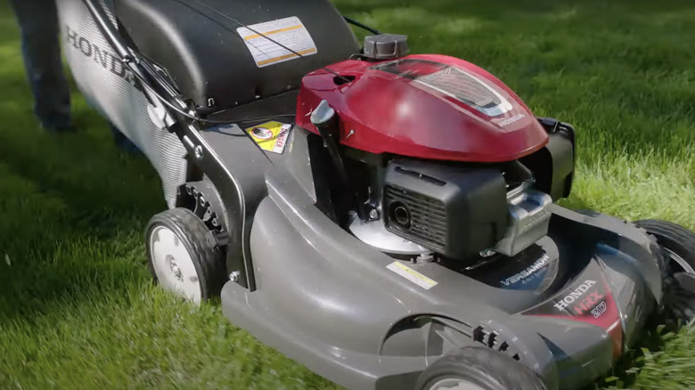 Person mowing lawn with Honda HRX217