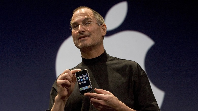 Steve Jobs holding up iPhone