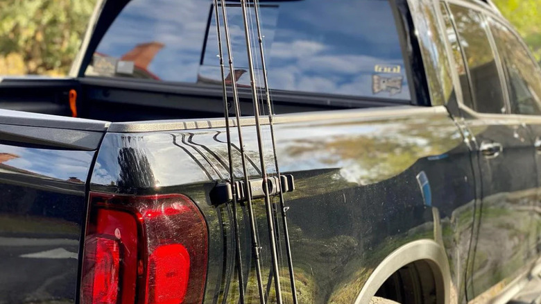 Gour fishing poles stand upright on the side of a truck with RigStrips' SunStrip