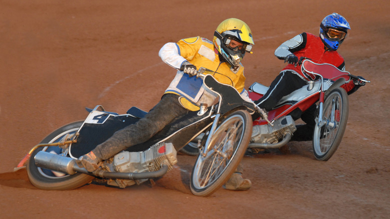 Speedway racers sliding around corner