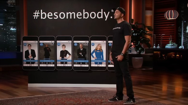 Kash Shaikh of Besomebody on Shark Tank in front of a row of giant phones