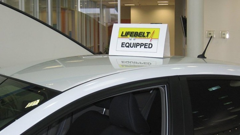 Lifebelt sign on white car in showroom