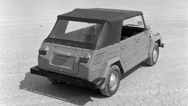 Black and white image of VW Thing parked in desert