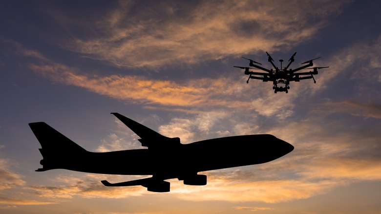 A drone flying near an aircraft in the afternoon sun