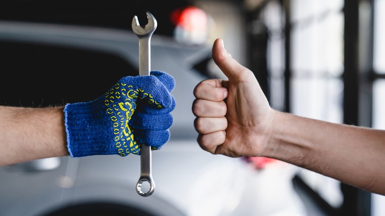 Car mechanic getting thumbs up