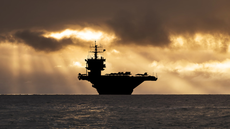 Aircraft carrier at sea sunset