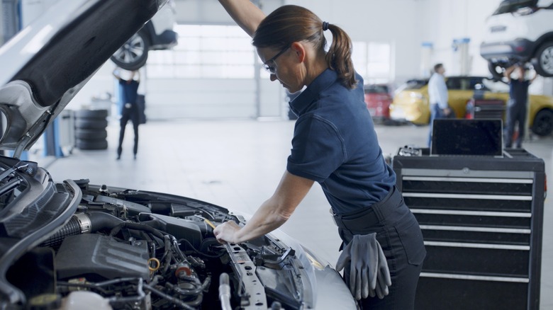 A mechanic inspecting a car's engine bay