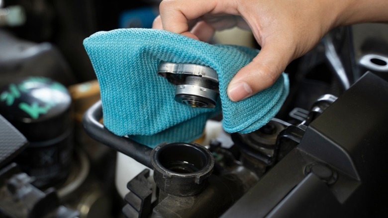 Close-up of a hand checking a car's radiator