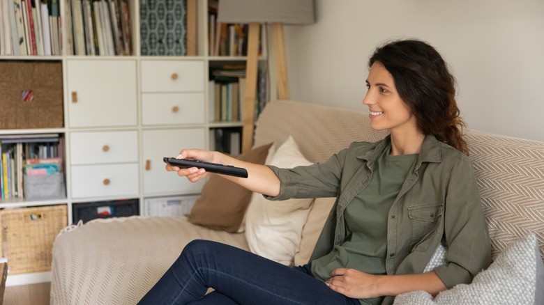 Woman pointing remote at TV