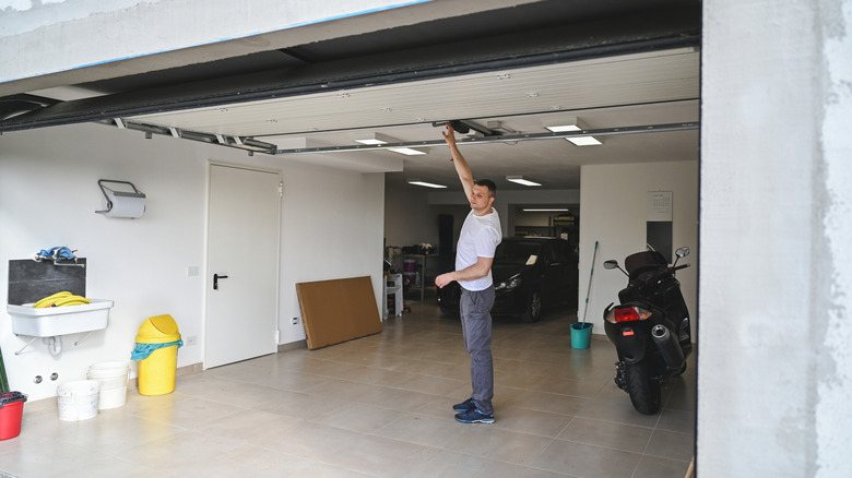 man reaching up to close garage door