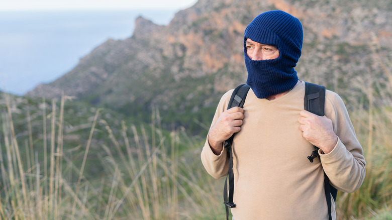 A mountain hiker wearing a dark blue balaclava.