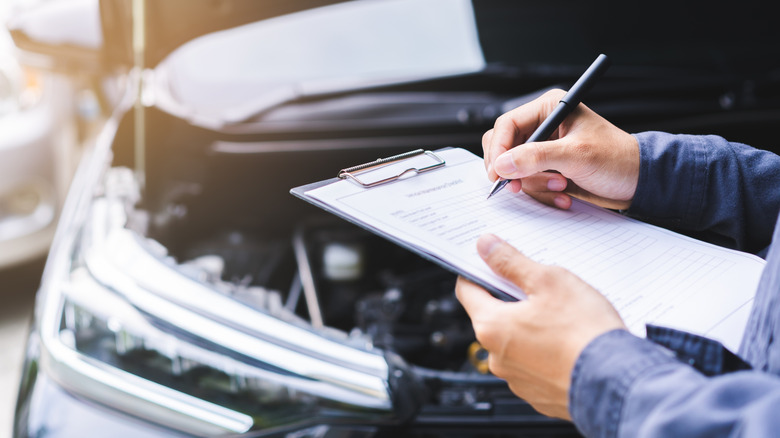 Mechanic checking engine to estimate repair machine