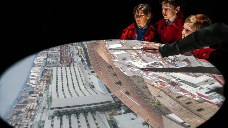 People viewing an image of downtown Sevilla, Spain, projected inside a camera obscura exhibit.