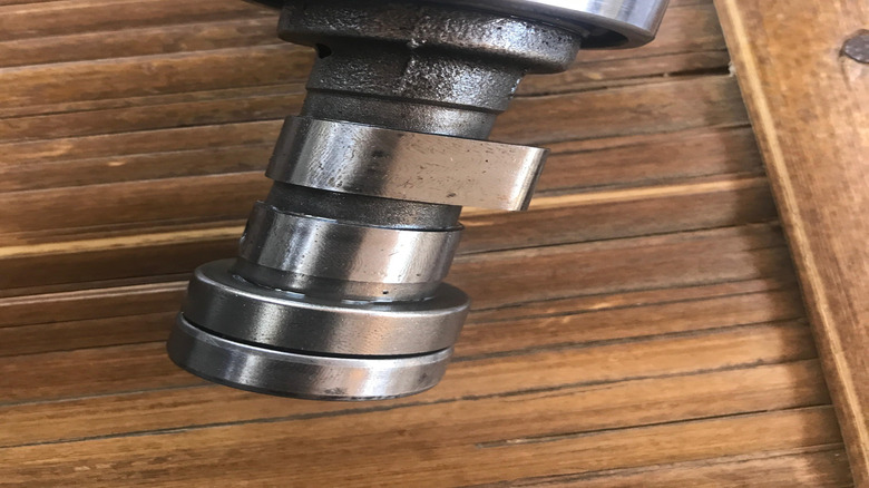 A vehicle camshaft on a surface