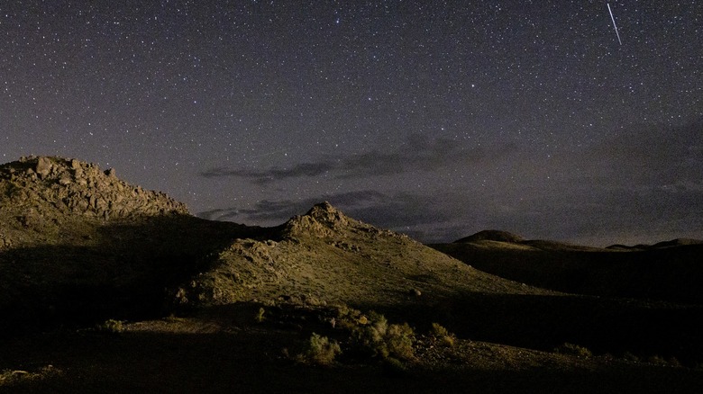 Low-light photograph of a mountain against the night sky