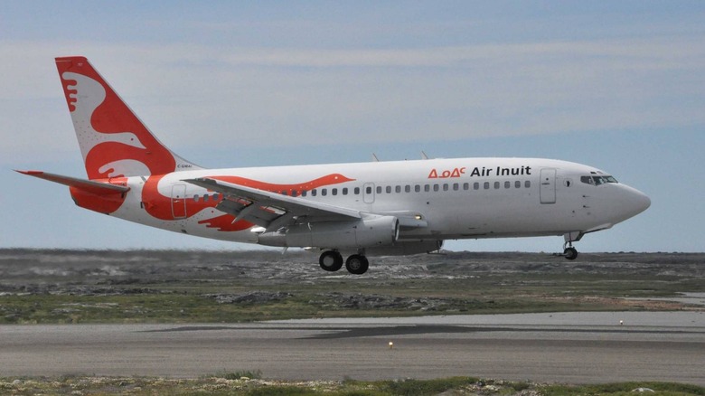 A Boeing 737 200C operated by Air Inuit lands on a gravel runway using a gravel kit