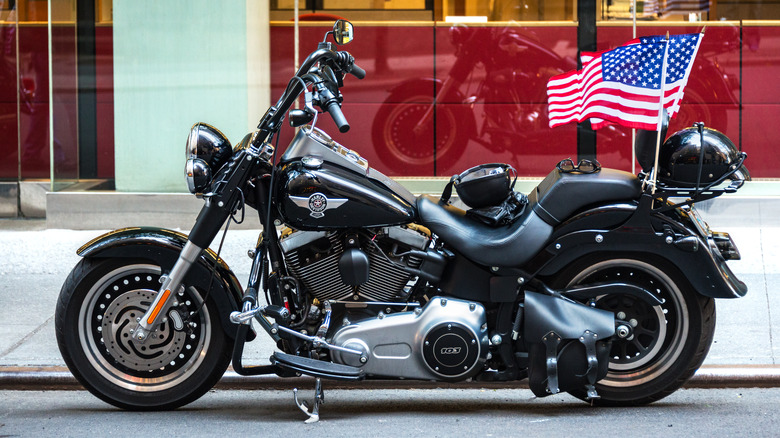 Harley-Davidson with American flag parked on curb