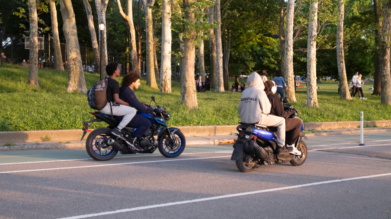 Teenagers on motorcycles without helmets