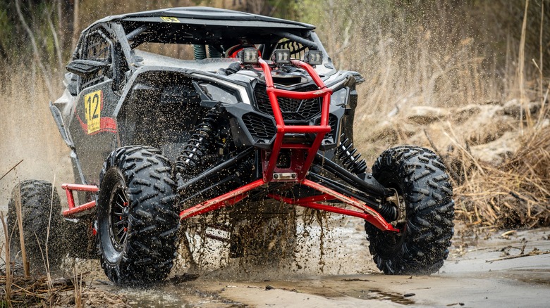 A UTV off-road in muddy water.