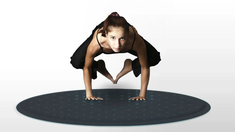 A woman balances on the Fluid Tera mat