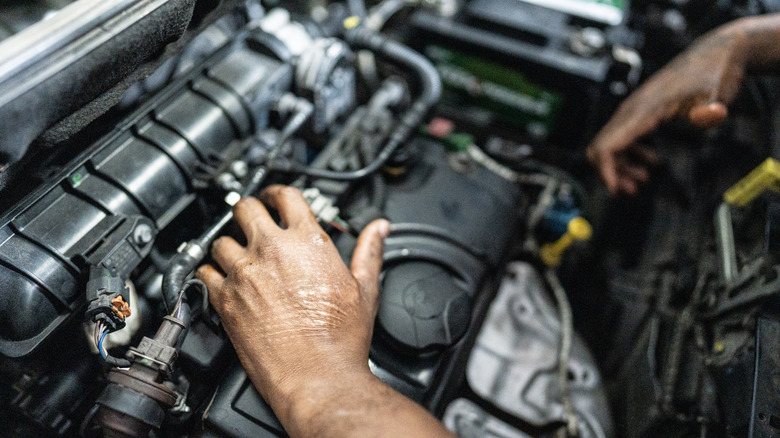 Mechanic working on car engine