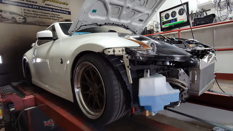 White Nissan 370Z on lift with hood raised for dynamometer testing